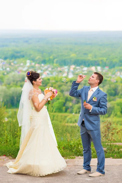 Hermosa boda pareja soplando burbujas —  Fotos de Stock