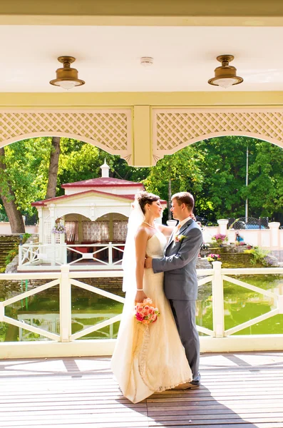 Mooie bruidspaar in park. kussen en omhelzen elkaar — Stockfoto