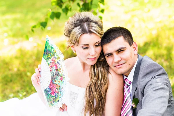 Elegante Braut und Bräutigam posieren zusammen im Freien an einem Hochzeitstag — Stockfoto