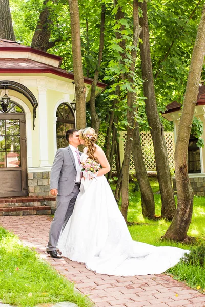 Şık gelin ve damat düğün günü dışarıda birlikte poz veriyorlar. — Stok fotoğraf