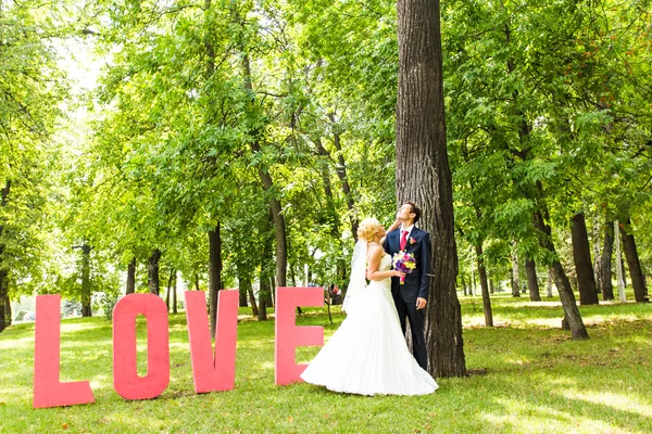 Щасливий наречений і наречений з листом слово любов — стокове фото
