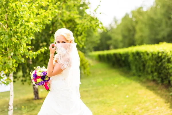Lyckliga bruden med bröllop bukett utomhus — Stockfoto