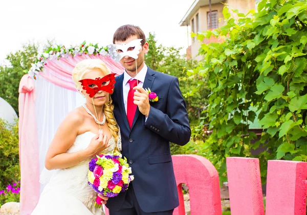 Νύφη και ο γαμπρός με Αστείες αποκριάτικες μάσκες — Φωτογραφία Αρχείου