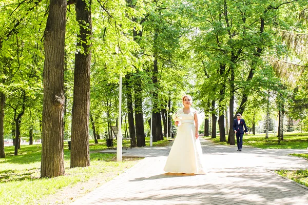 Giovane bella sposa attende lo sposo nel parco primaverile — Foto Stock
