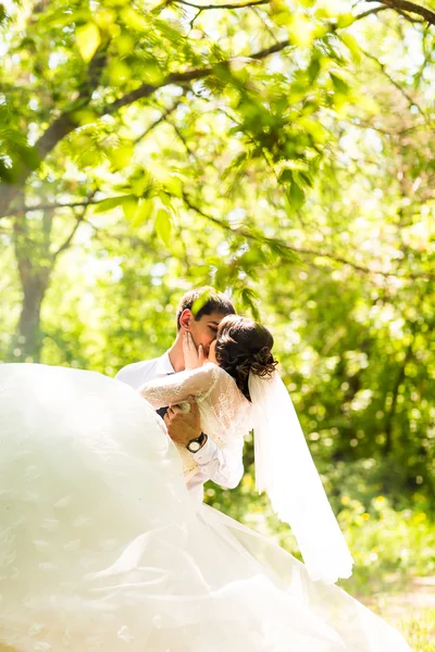Jovem noivo carregando sua bela esposa — Fotografia de Stock