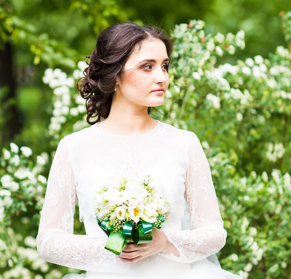 Bela noiva em vestido branco no jardim da primavera — Fotografia de Stock