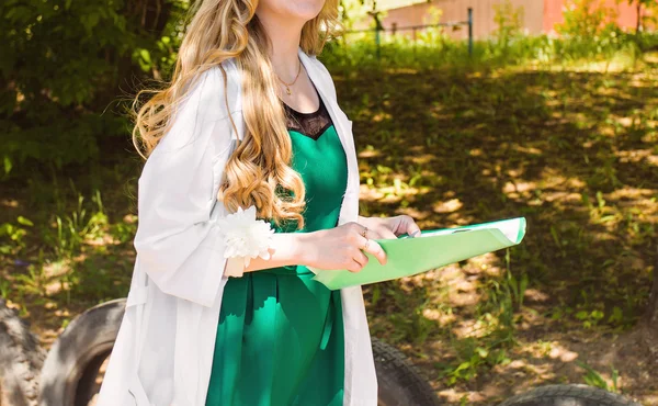 Hermosa joven doctora en bata médica con un historial médico. enfermera con antecedentes médicos — Foto de Stock
