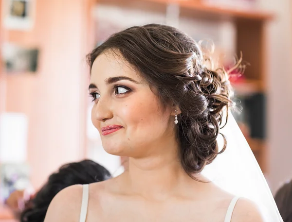 Bela noiva jovem com maquiagem de casamento e penteado no quarto, recém-casada mulher preparação final para o casamento. Noiva feliz esperando noivo. Casamento momento do dia do casamento. Retrato de noiva foco suave — Fotografia de Stock