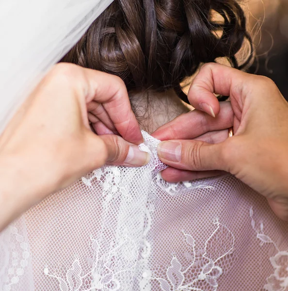 Bridesmaid is helping the bride to dress — Stock Photo, Image