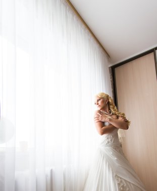 güzel genç gelin düğün makyaj ve saç yatak ile çekici yeni evli kadın son düğün hazırlığı var. mutlu gelin bekleyen damat. evlilik düğün günü anı. Gelin portresi