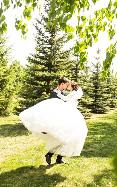 Jovem noivo carregando sua bela esposa — Fotografia de Stock