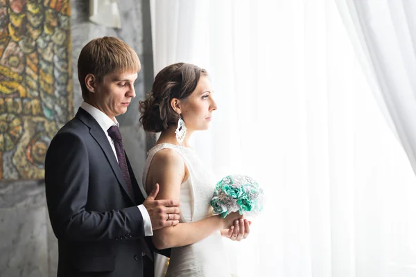 Bella sposa e sposo vicino alla finestra . — Foto Stock