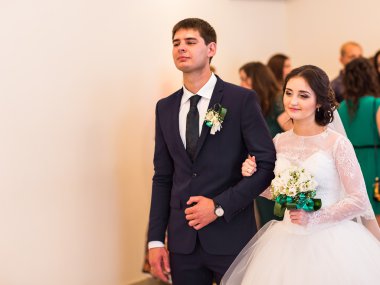 Gelin ve damat birbirlerinin düğün töreni sırasında el ele tutuşarak
