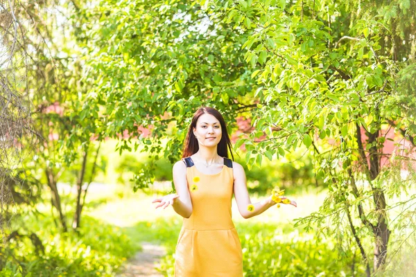 Asiático mulher jogando pétalas no primavera jardim — Fotografia de Stock