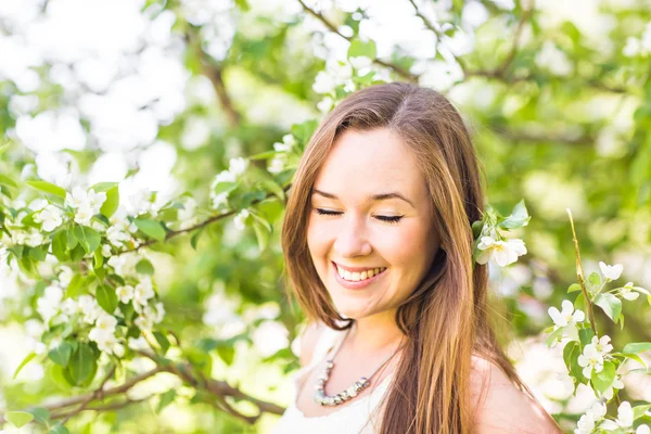 Romantische jonge vrouw in de lentetuin onder appel bloesem, soft focus Sea... — Stockfoto