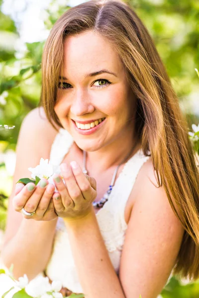 Mujer joven romántica en el jardín de primavera entre flor de manzana, enfoque suave — Foto de Stock