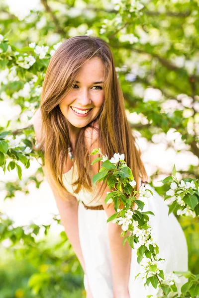 Hermosa joven feliz en el jardín de primavera entre flor de manzana, enfoque suave — Foto de Stock