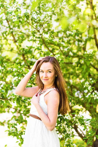 Hermosa mujer joven en el jardín de primavera entre flor de manzana, enfoque suave — Foto de Stock