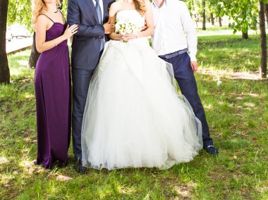 Mutlu gelin ve damat ile misafirler bahçede duran