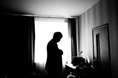 Onun en sevdiğim gömlek giymiş. Kadar gömlek düğmelerini adam silüeti