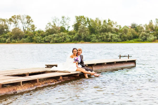Bela noiva e noivo perto de um lago ou rio — Fotografia de Stock