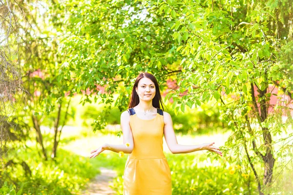 Aziatische vrouw gooien bloemblaadjes in lentetuin — Stockfoto