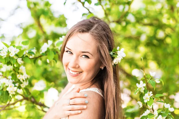 Romantica giovane donna nel giardino primaverile tra i fiori di melo, soft focus — Foto Stock