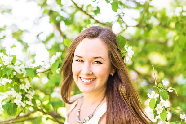 Mujer joven romántica en el jardín de primavera entre flor de manzana, enfoque suave — Foto de Stock