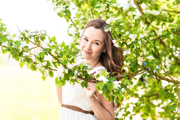 Schöne junge Frau im Frühlingsgarten zwischen Apfelblüten, weicher Fokus — Stockfoto