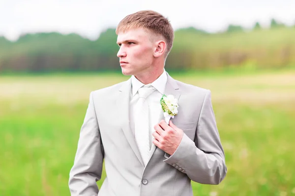 Very beautiful buttonholes on the jacket of a young and handsome groom — Stock Photo, Image