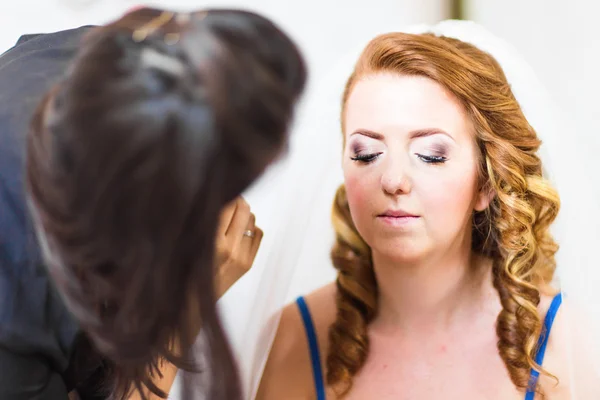 Fiatal gyönyörű menyasszony alkalmazása esküvői smink a sminkes — Stock Fotó