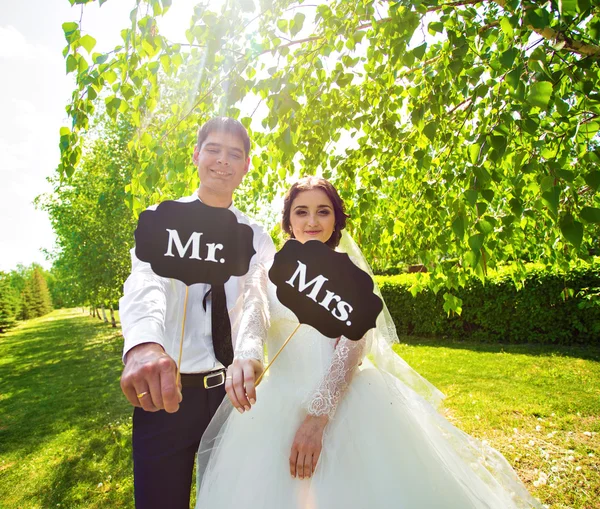 Pengantin wanita dan pengantin pria yang lucu dengan Mr dan Mrs tanda-tanda. Selamat hari pernikahan. — Stok Foto