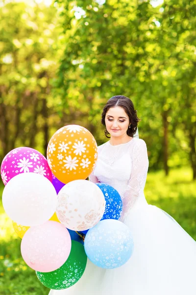 Веселая невеста позирует с кучей шариков — стоковое фото