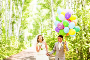 Güzel gelin ve damat bir parkın renkli balonlar ile