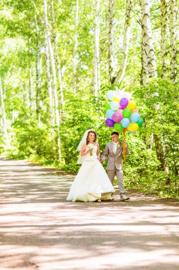 Güzel gelin ve damat bir parkın renkli balonlar ile