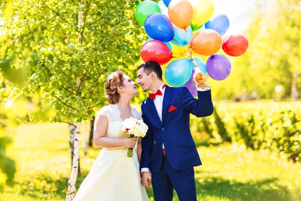 Красива наречена і наречений на парку з різнокольоровими повітряними кулями — стокове фото