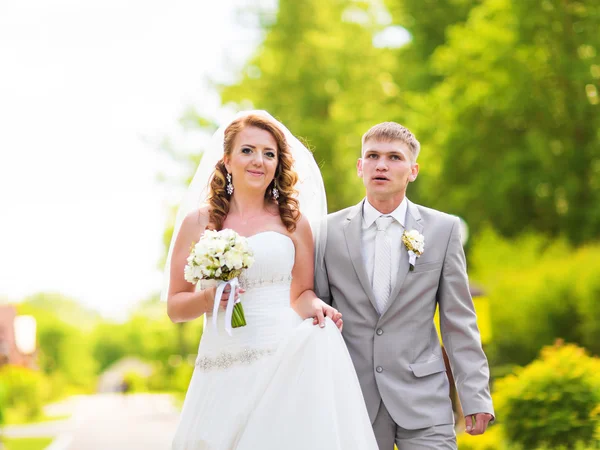 Жених и невеста держатся за руки на улице — стоковое фото