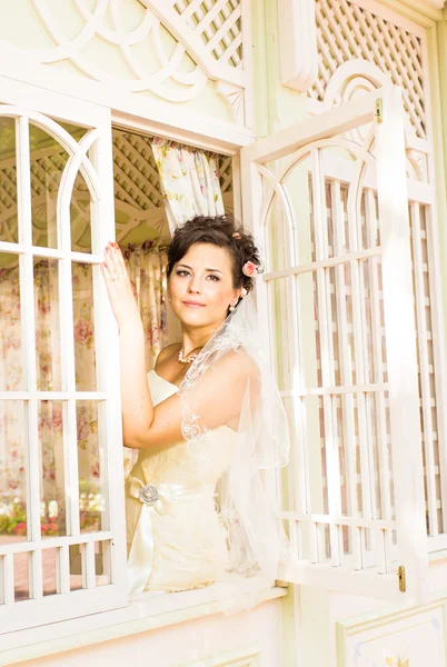 Junge schöne Braut wartet auf Bräutigam am Fenster. schöne Braut vom Sonnenlicht beleuchtet. schöne junge Braut wartet — Stockfoto