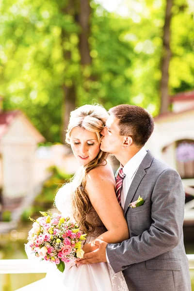 Marié embrassant mariée le jour de leur mariage — Photo