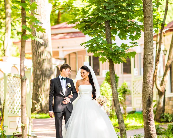 Mariée et marié le jour du mariage Promenade en plein air sur la nature printanière. Couple nuptial, heureuse femme mariée et homme embrassant dans un parc verdoyant. Amour couple de mariage en plein air — Photo