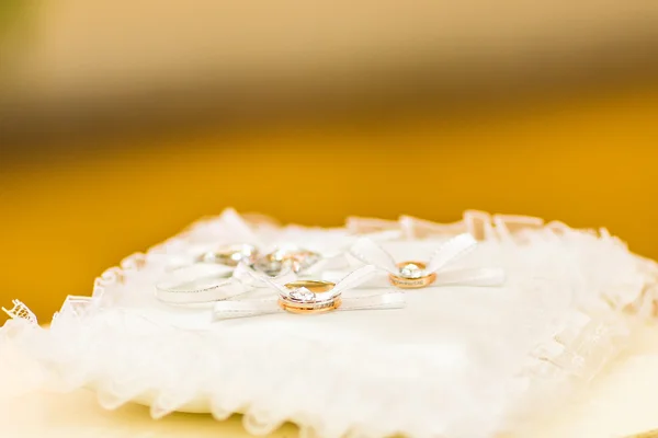 Anéis de casamento de ouro na almofada — Fotografia de Stock