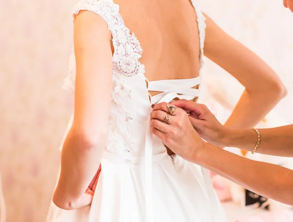 花嫁介添人の結婚式のドレスに弓を結ぶこと — ストック写真