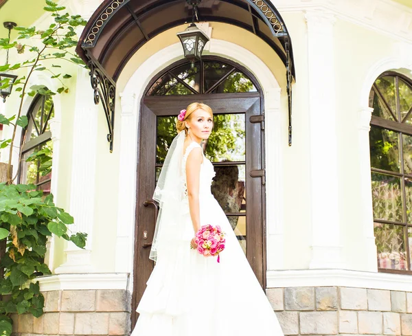 Gyönyörű menyasszony lány csokor virágot, szabadban álló esküvői ruha — Stock Fotó