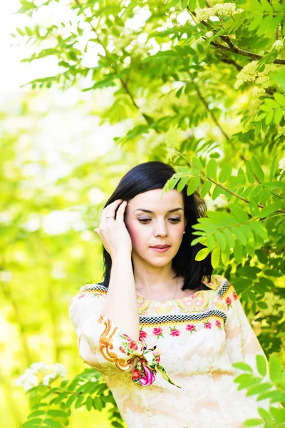 Mulher bonita de pé em um parque na primavera ou verão — Fotografia de Stock