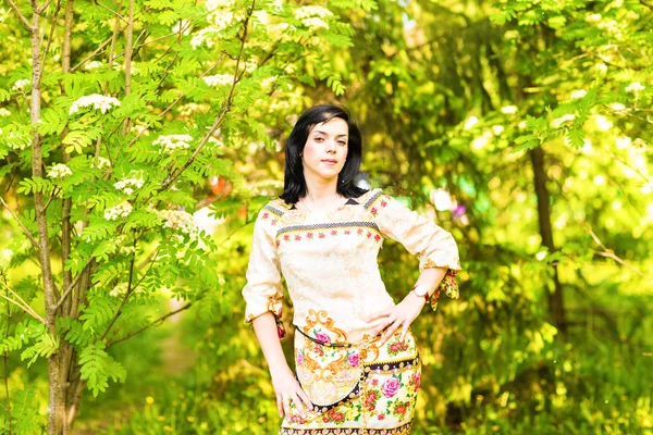 Mulher bonita de pé em um parque na primavera ou verão — Fotografia de Stock