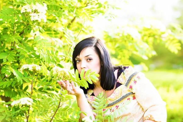 Mulher bonita de pé em um parque na primavera ou verão — Fotografia de Stock