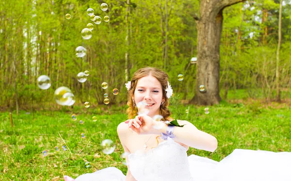 Невеста играет с мыльным пузырем и улыбкой радости — стоковое фото