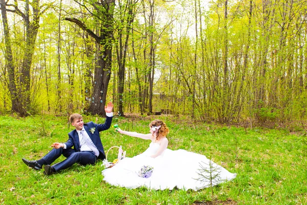 Свадебная пара играет с мыльным пузырем и улыбкой радости — стоковое фото