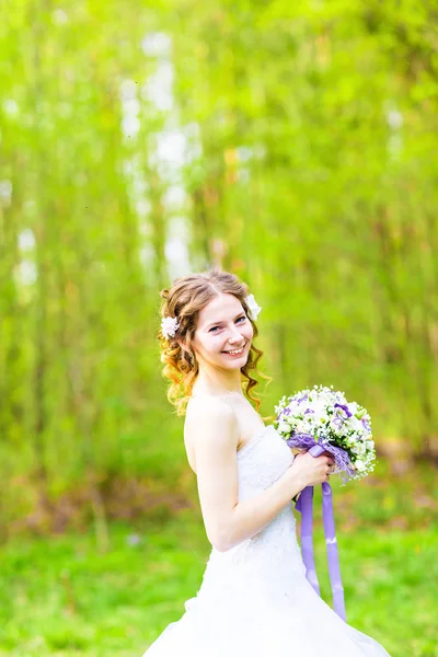 Bela noiva com buquê de flores ao ar livre — Fotografia de Stock