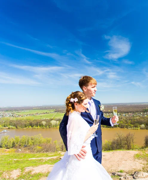 Наречений і наречений з келихами шампанського в день весілля — стокове фото